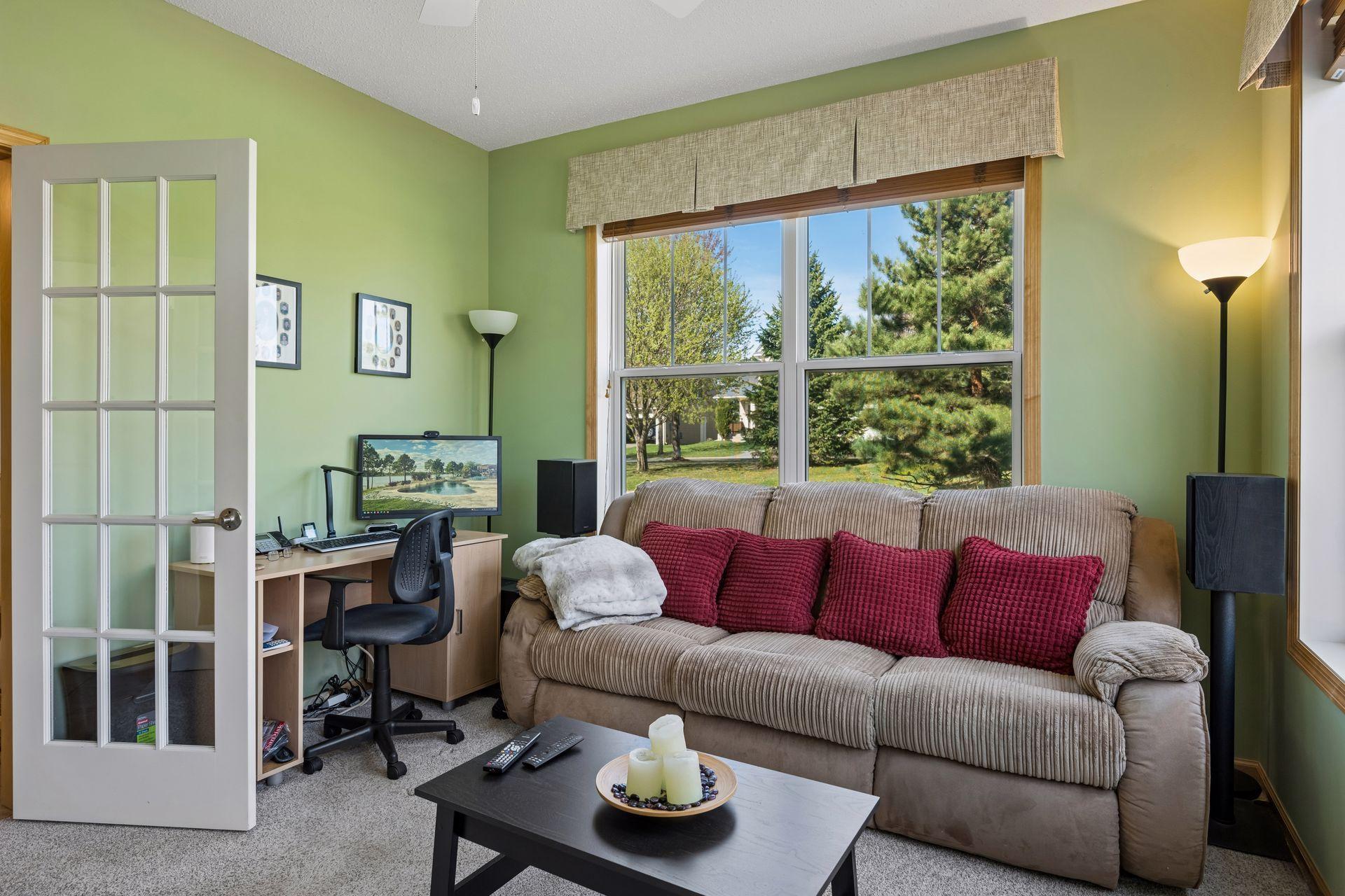 Another angle of the den/sunroom showing the glass entry door and front yard views.