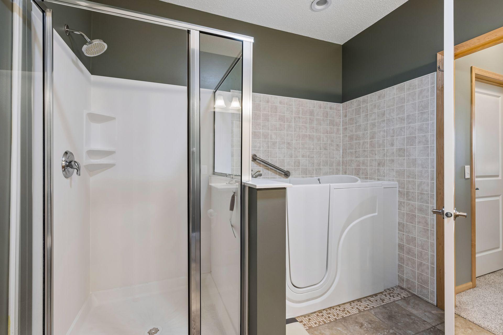 Note the bath in the primary suite is a handicap accessible "premier bath" that features a seat with a hand shower as well as the ability to function as a normal bathtub.