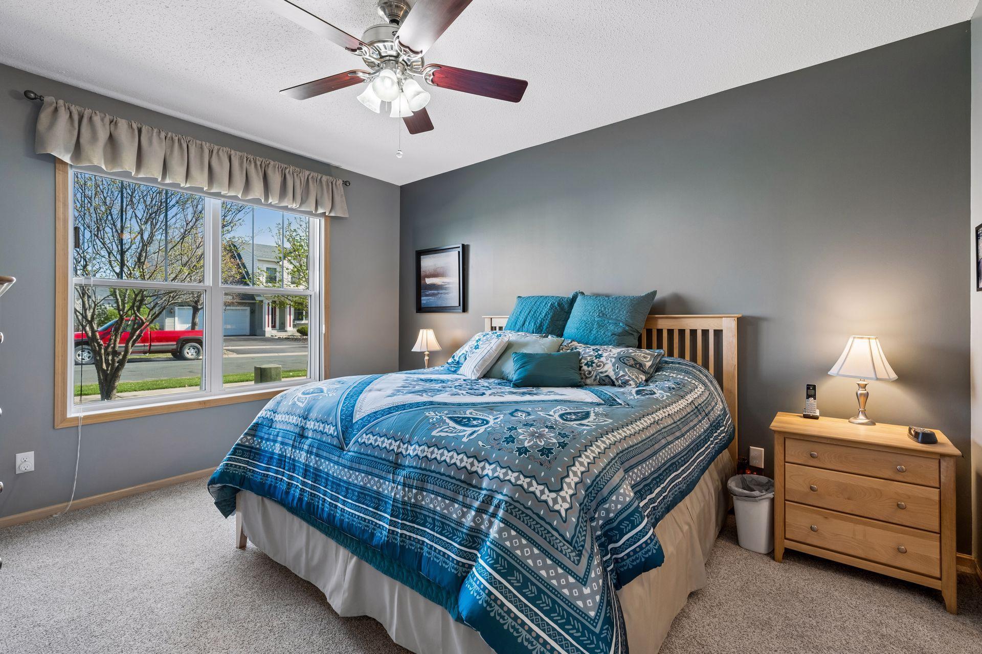 Generous primary bedroom features windows to the side of the home and ceiling fan/light.