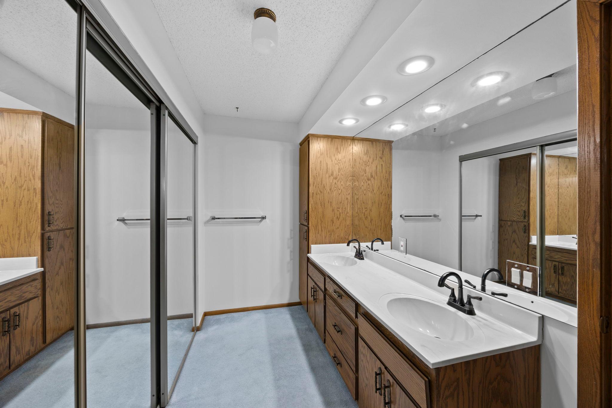 The private ensuite bathroom adds even more storage with an additional closet, dual vanity, walk-in shower, and floor-to-ceiling linen cabinetry, offering outstanding organization and functionality.