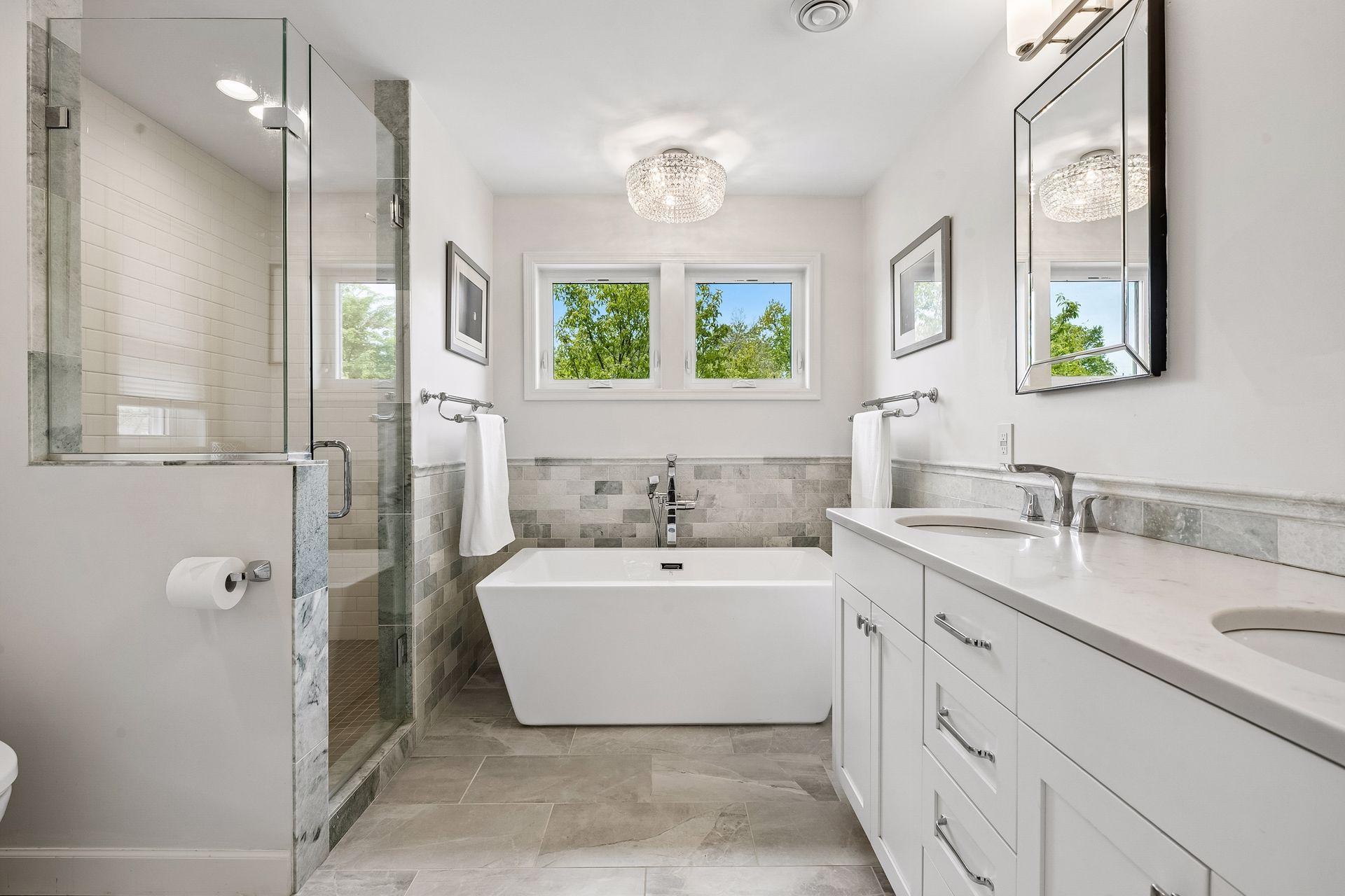 Sumptuous primary bathroom is a welcome respite from the hustle and bustle, with designer soaking tub, dual sinks, beautiful tilework and shower.