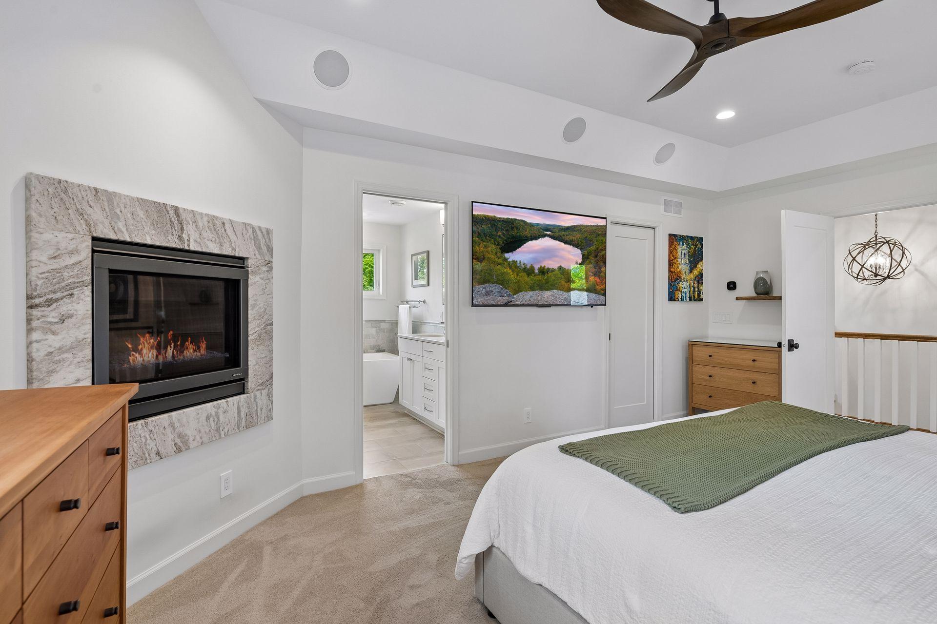 Primary suite with built-in surround speakers, view of bath, closet, and hallway.