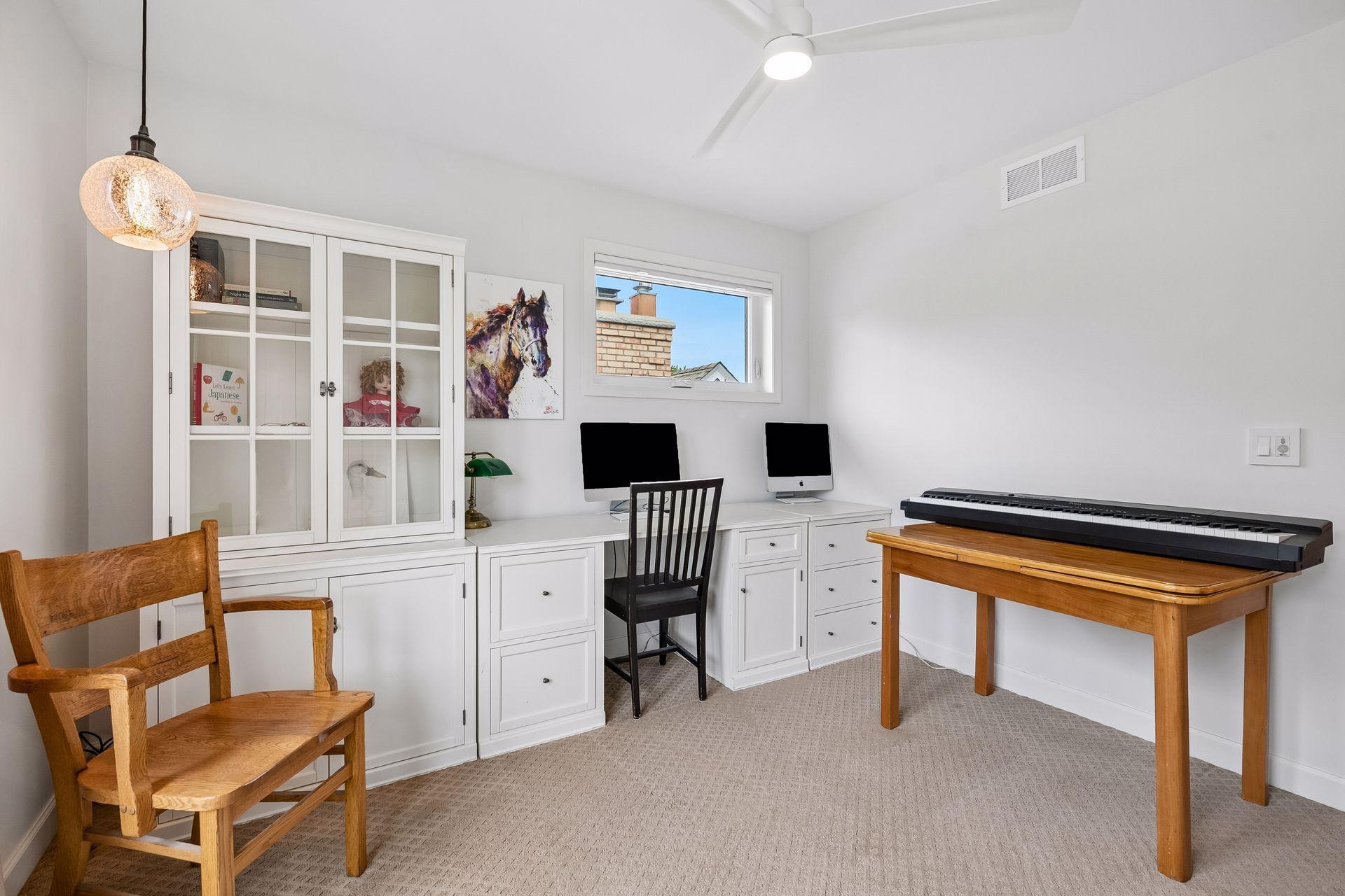 One of three bedrooms upstairs, with built-in desk and cabinetry.