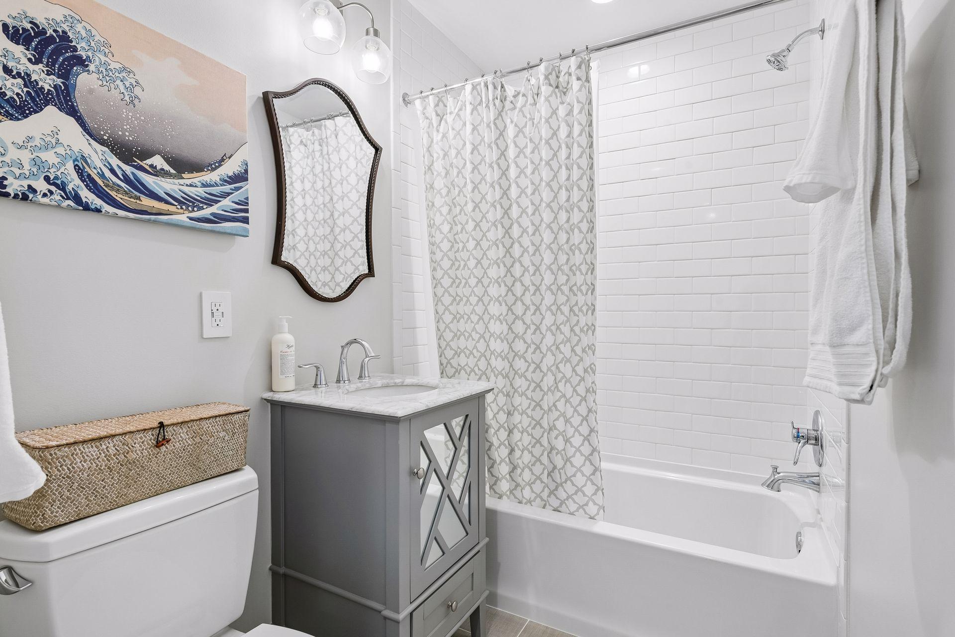 Full guest bathroom upstairs, with tiled floor and white subway tiled shower.