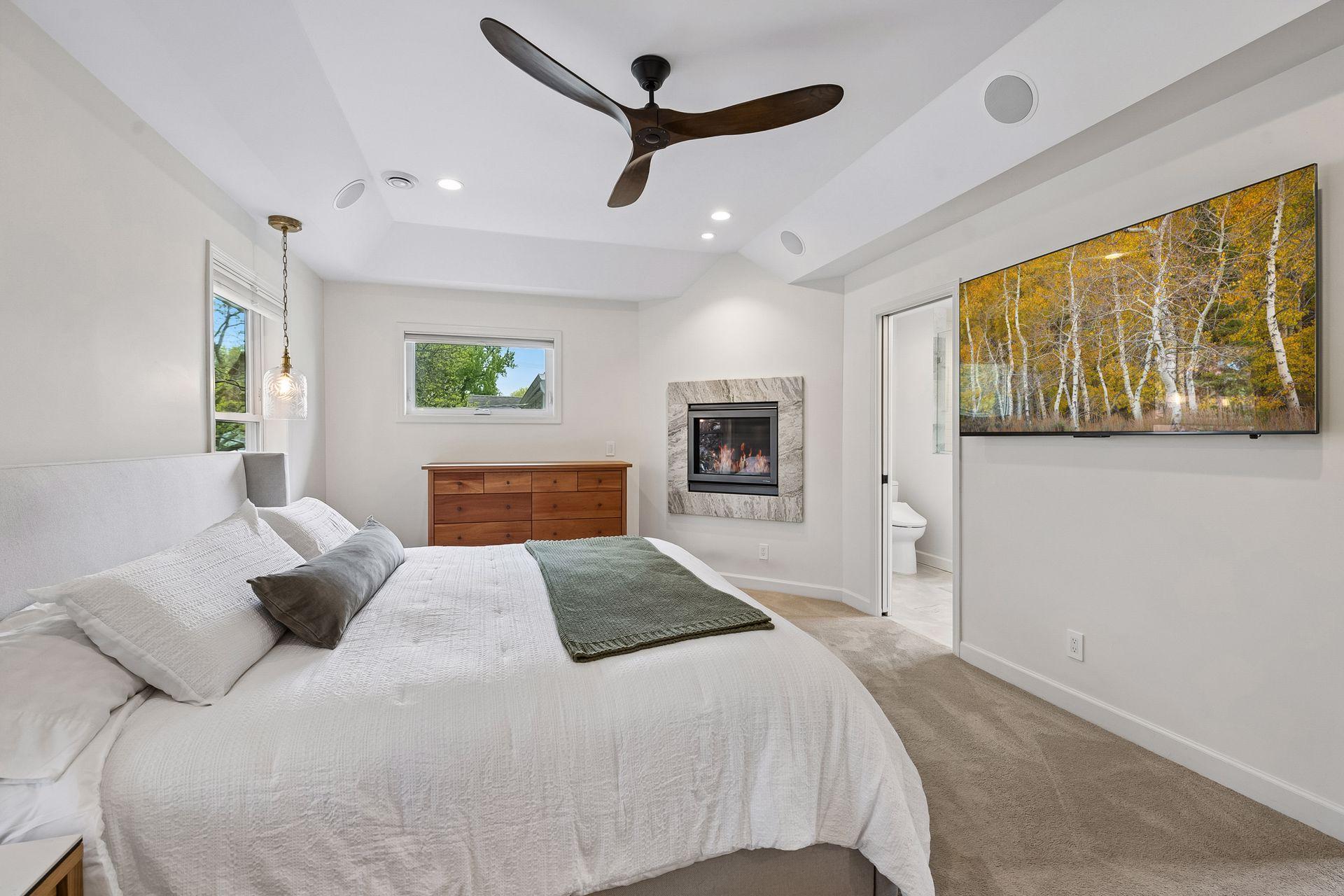 One of three bedrooms upstairs, the primary suite features tray ceilings, gas fireplace, ensuite full bathroom, and walk-in closet.