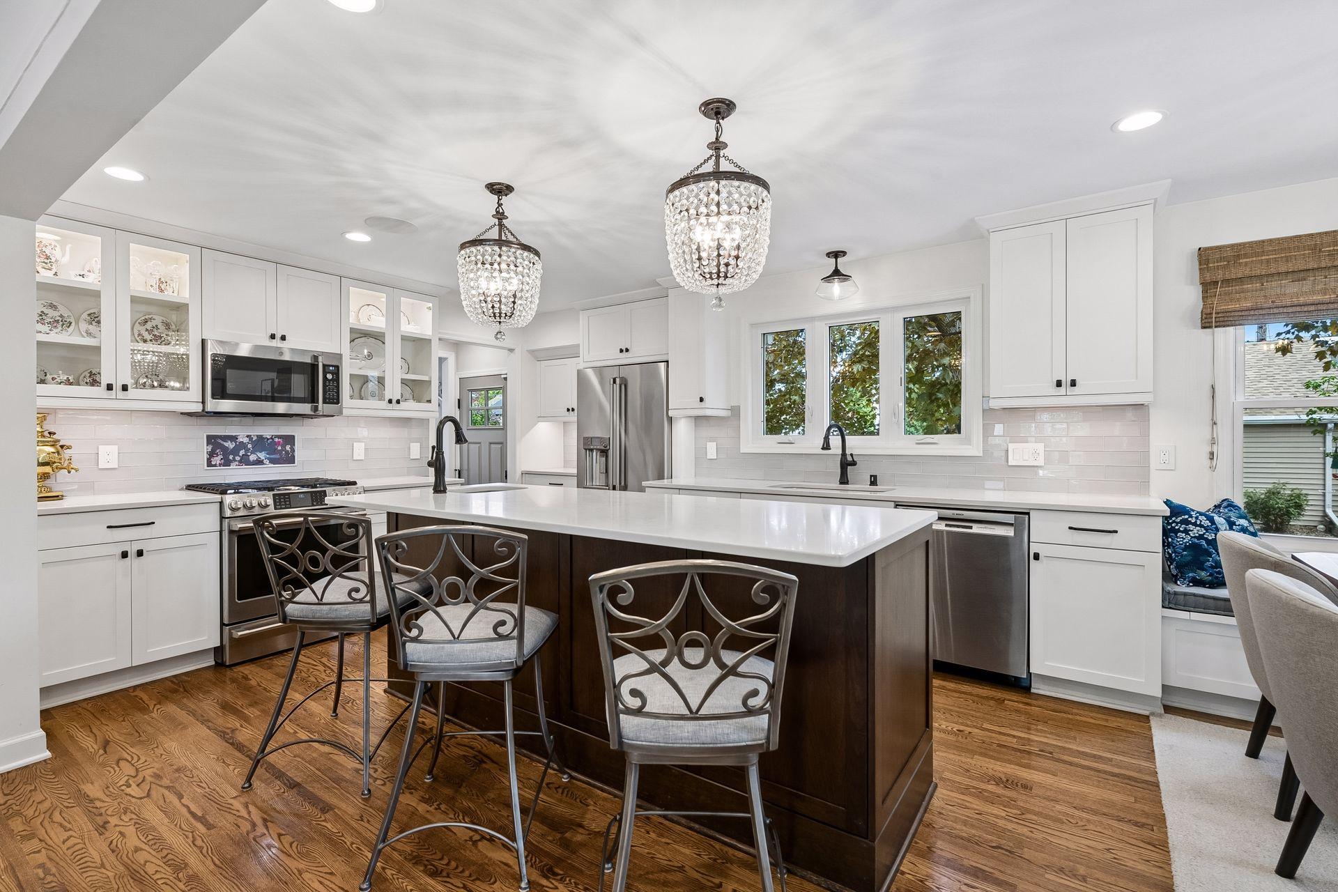 The heart of the home, this kitchen does not disappoint with ample updated cabinetry, quartz tops and stainless appliances. Adjacent eat-in bench nook and rear mudroom/pantry in background.