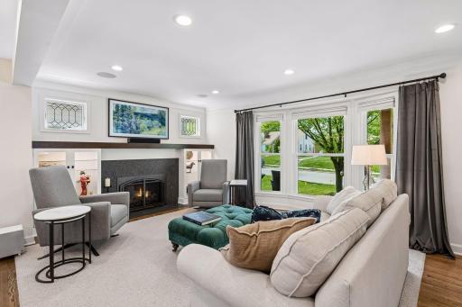 Front living room area overlooks quiet, tree-lined Newton Avenue, with lighted built-ins and custom-made beveled windows surrounding the updated fireplace area, updated lighting and restored hardwood floors.