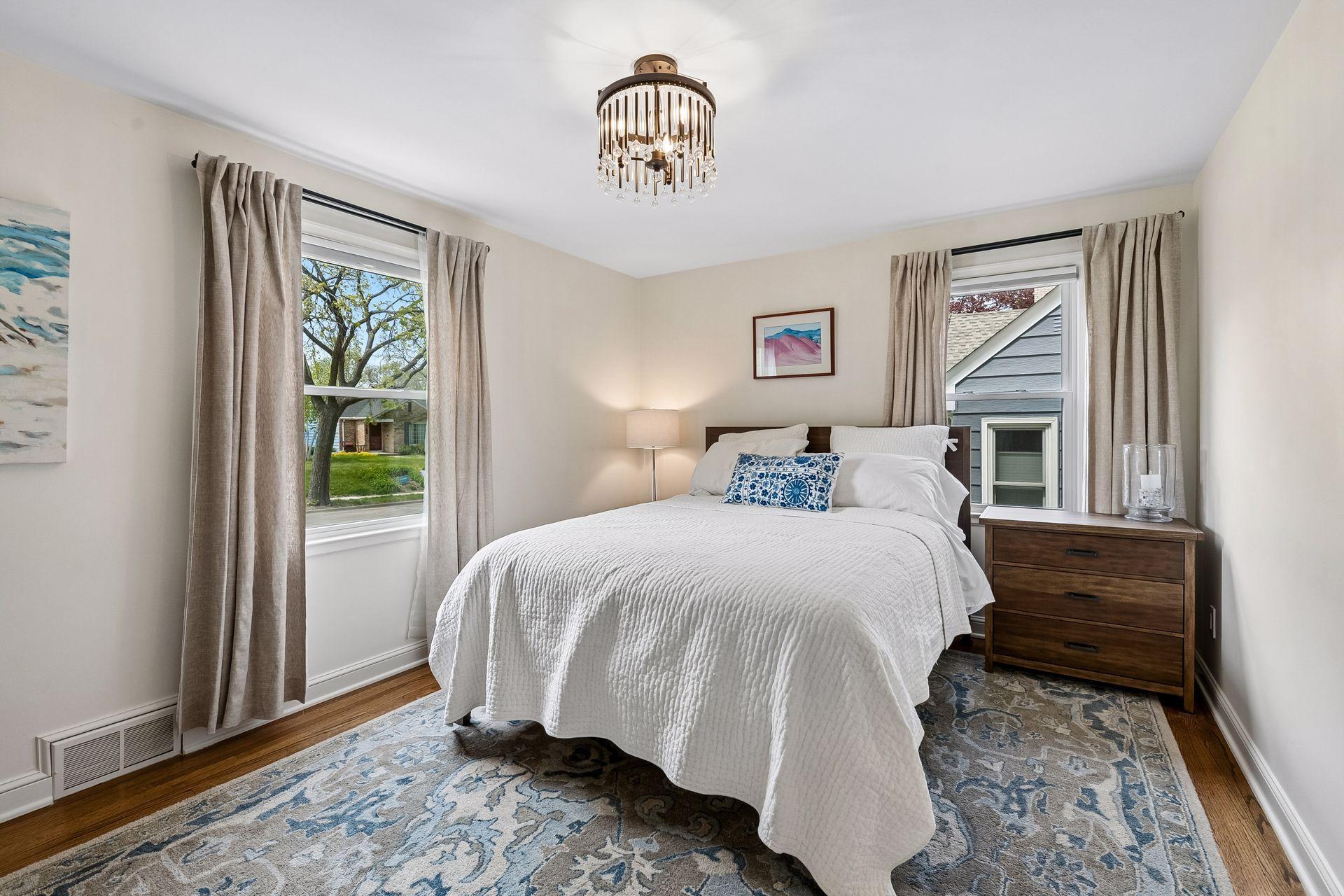 Main floor bedroom with hardwood flooring, large windows and near full main floor guest bathroom.