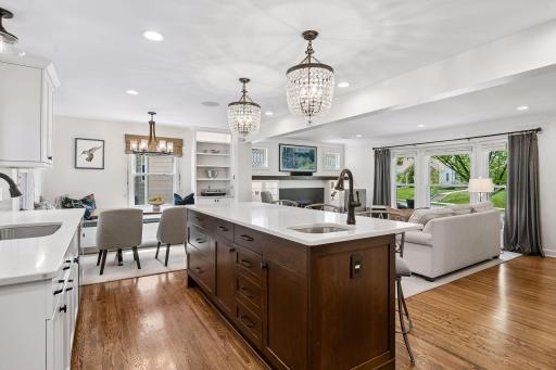 View over the center island of dining area and living room. Note the dining area to the left with additional built-in hutch storage and "L" shaped bench seating.