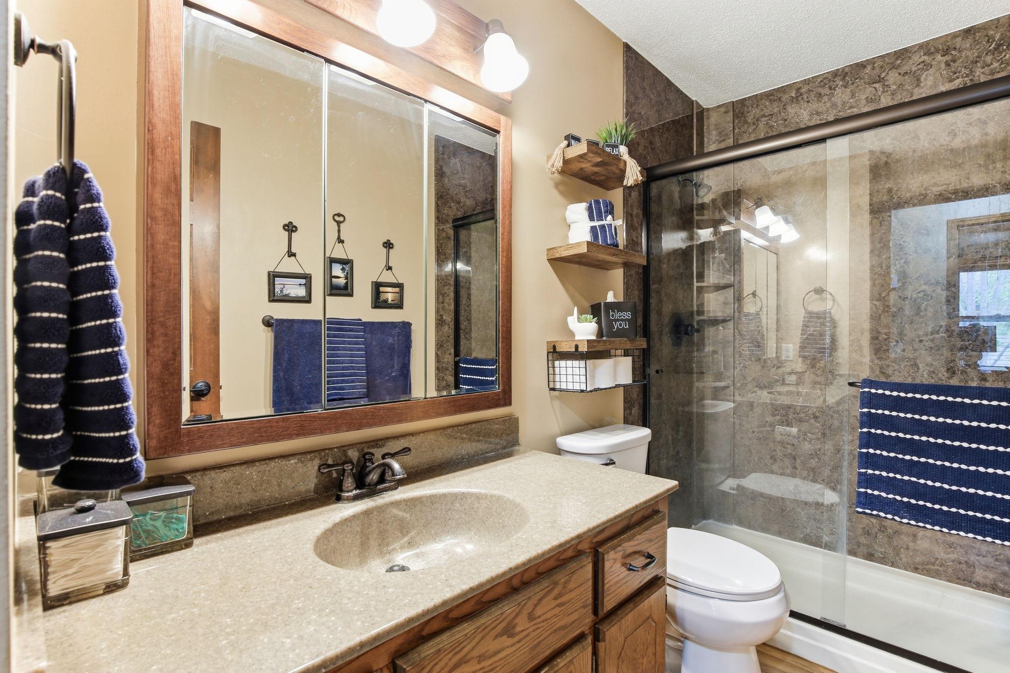 Main-level 3/4 updated bath featuring modern finishes and a refreshed design, offering a sleek, functional space with a contemporary shower and stylish fixtures.