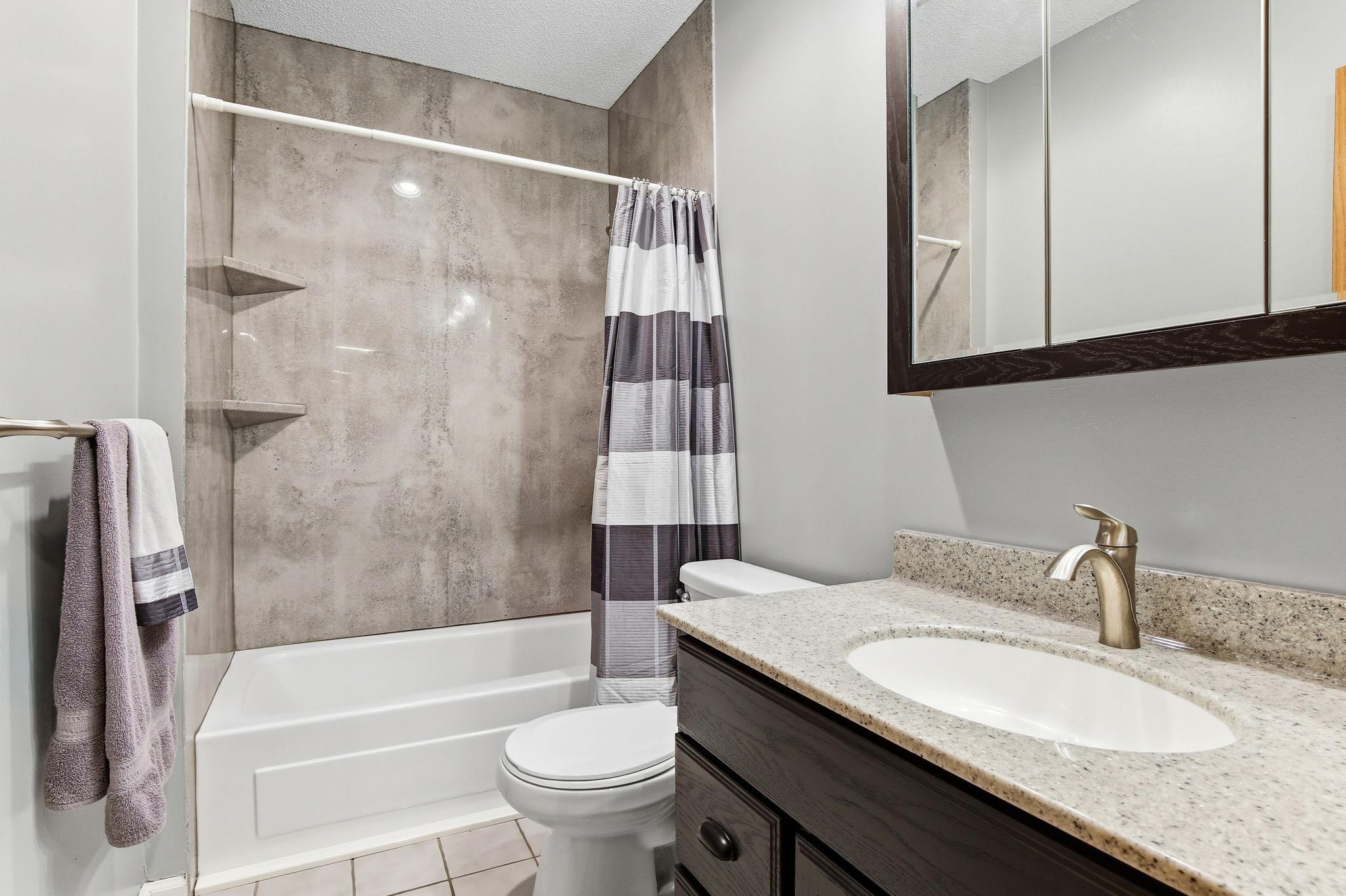 Updated full lower-level bath featuring a refreshed, modern design with a full tub and shower combination, offering a clean and comfortable space for guests or everyday use.