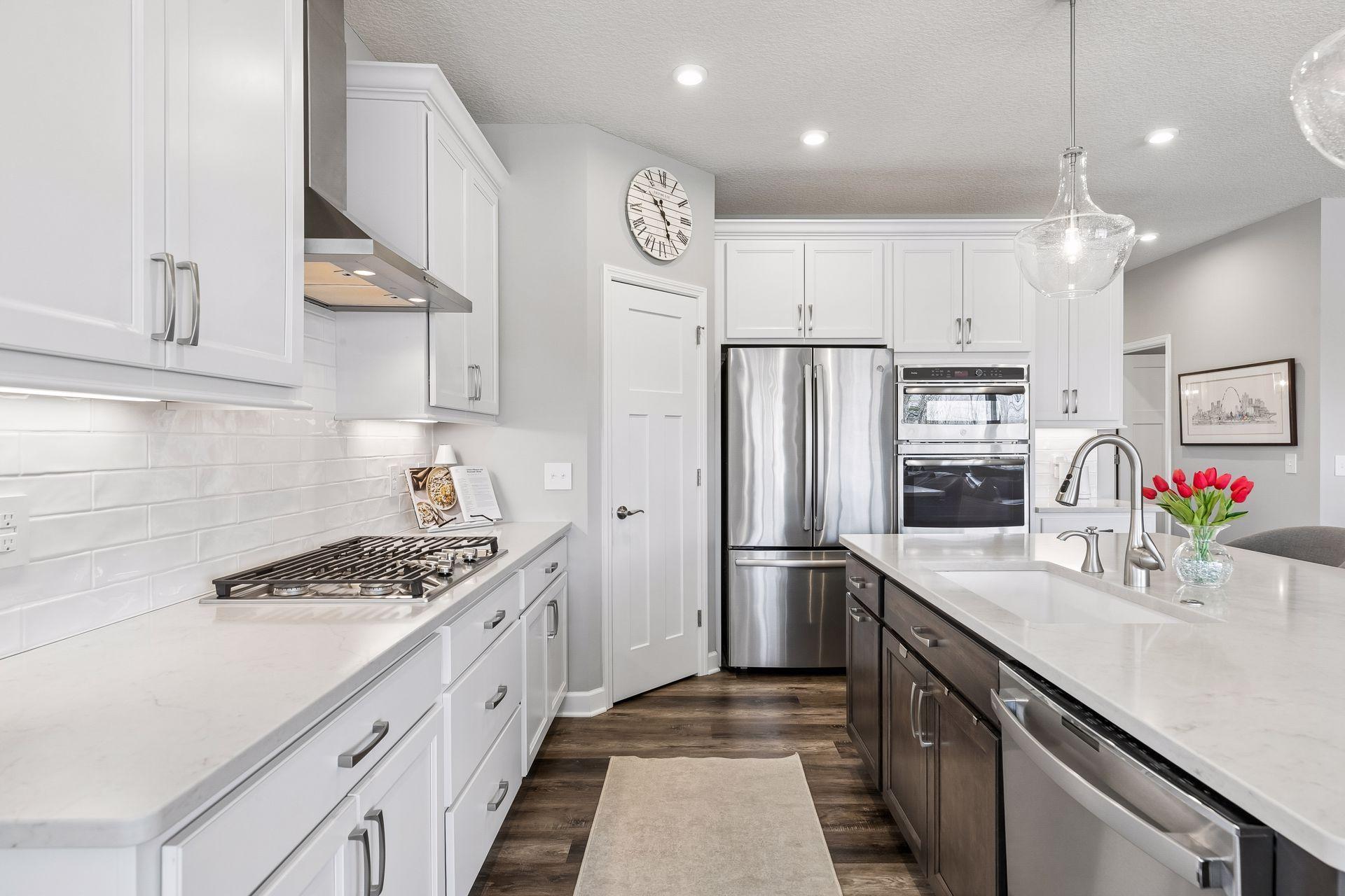 Timeless shaker style cabinets, quartz countertops, white subway tile add a fresh, clean and modern feel to this kitchen. Lower cabinets have full extension roll out shelves. Note: under cabinet lighting as well.