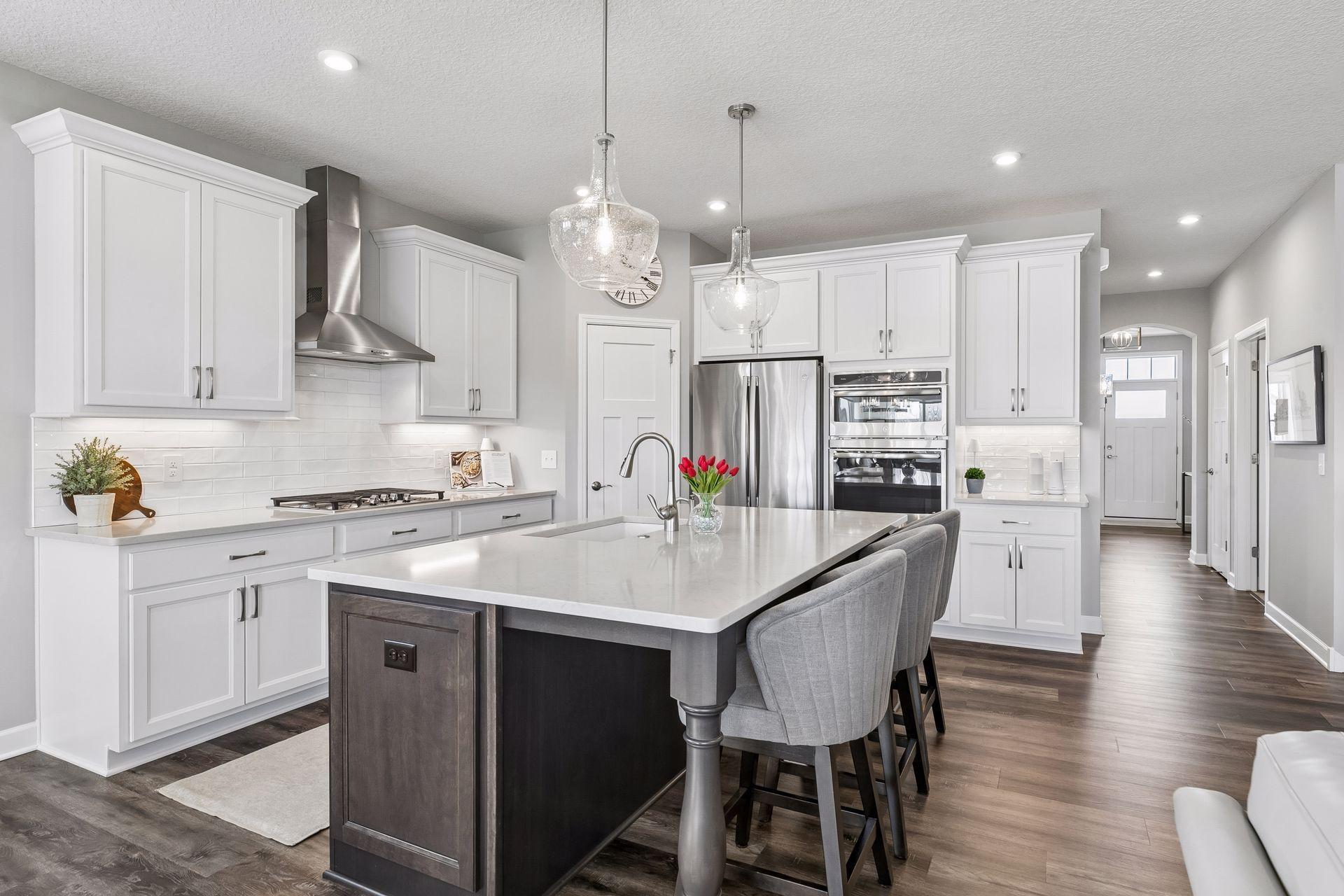 The large center island with richly stained wood base adds a stunning contrast and serves as both a prep space and casual seating area.