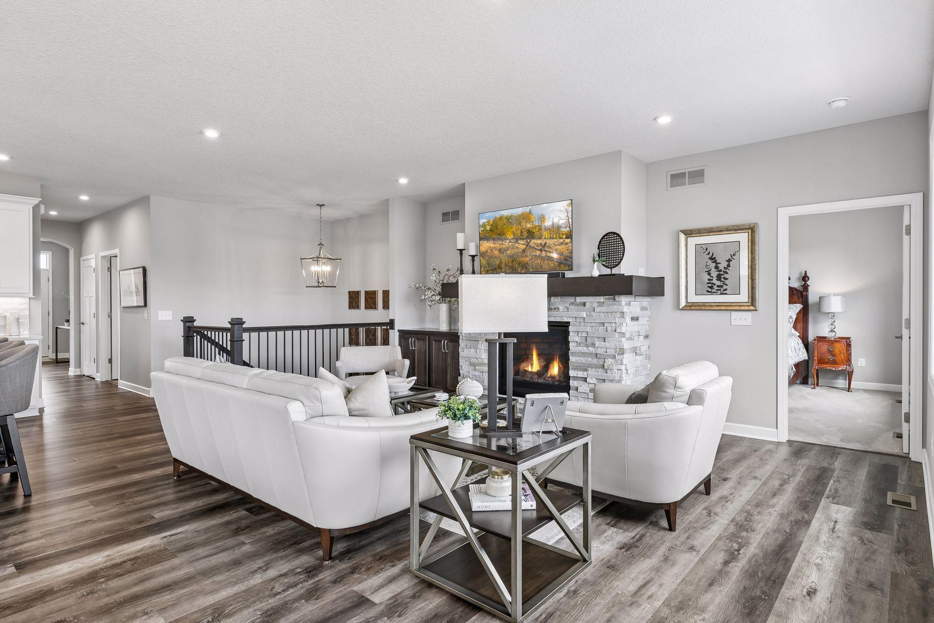 The main level features higher base trim that was finished on-site. The Luxury Vinyl Plank (LVP) flooring extends into the living room, allowing for flexible furniture placement.