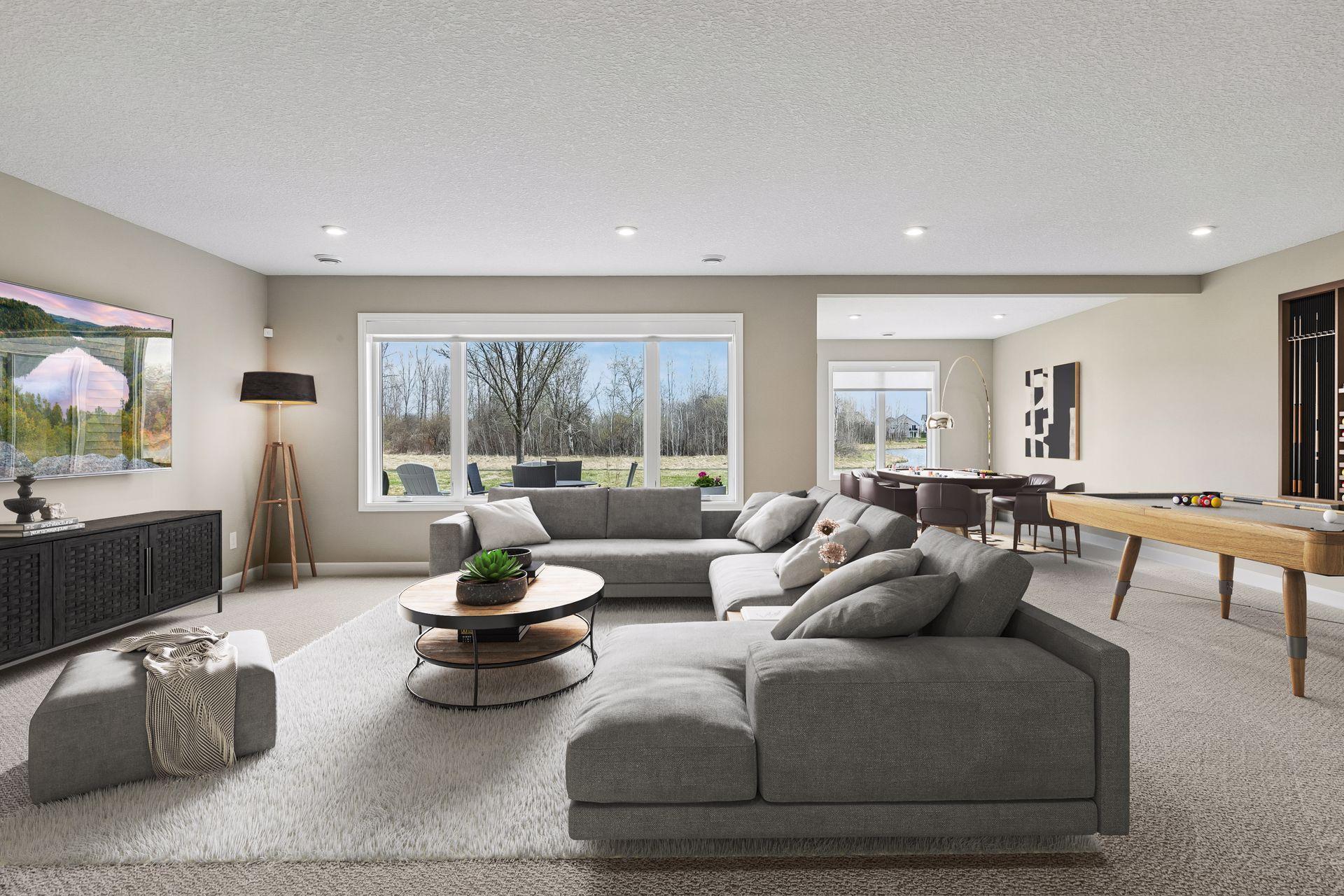 The finished lower level offers a large living and entertaining space. (Virtual staged in this photo)