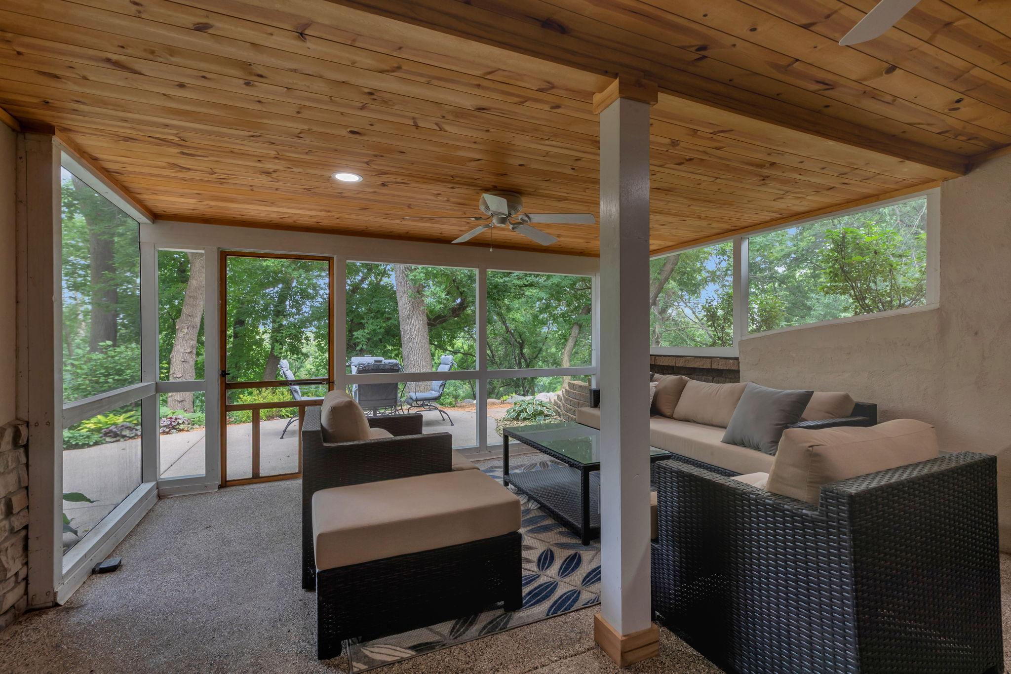 Spacious three-season porch features charming knotty pine ceilings and provides direct access to the spectacular backyard retreat!