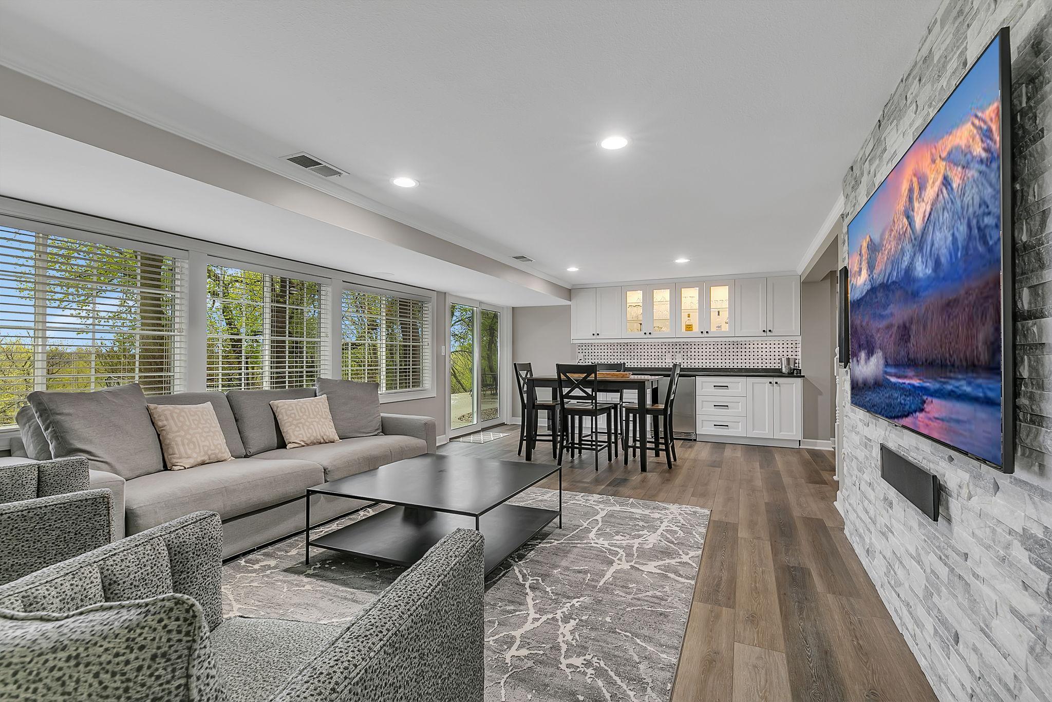 Beautiful Walk-Out Lower Level With A Fresh New Look Which Includes A Family Room And Bar Area, With A Seamless Transition To A Lovely Patio And Sitting Area Offering A Serene View Of The Backyard Sanctuary!