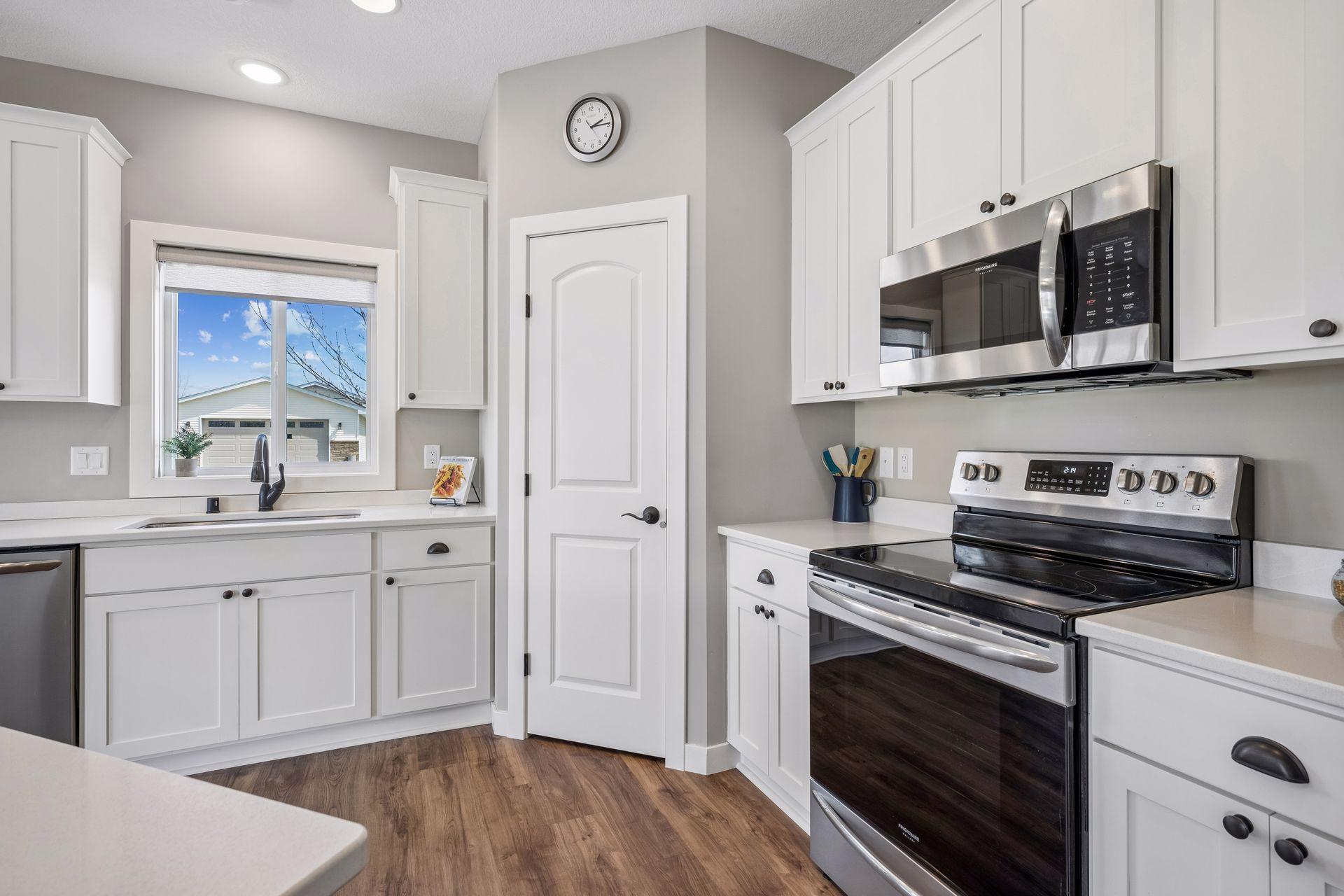 Kitchen window over the sink, with an electric shade and stainless steel sink.