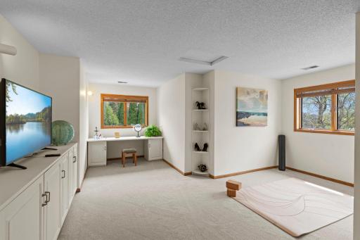 Extending from the suite is a private bonus room with a built-in entertainment center, desk, and wall shelving.
