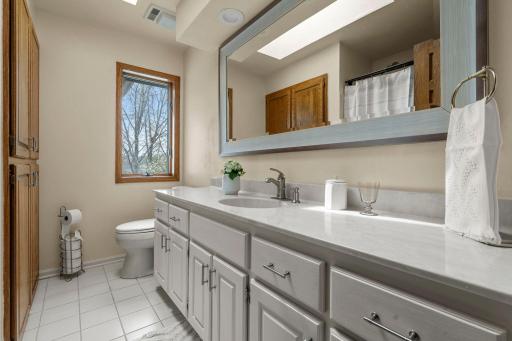 A full bathroom serves the upper level, complete with extended counter space and linen cabinetry for added storage.