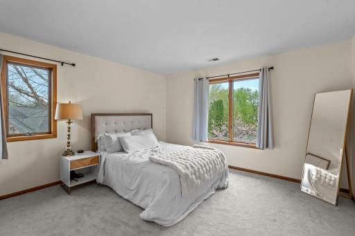Two additional bedrooms on the upper level offer continuous carpeting and generous closet space.