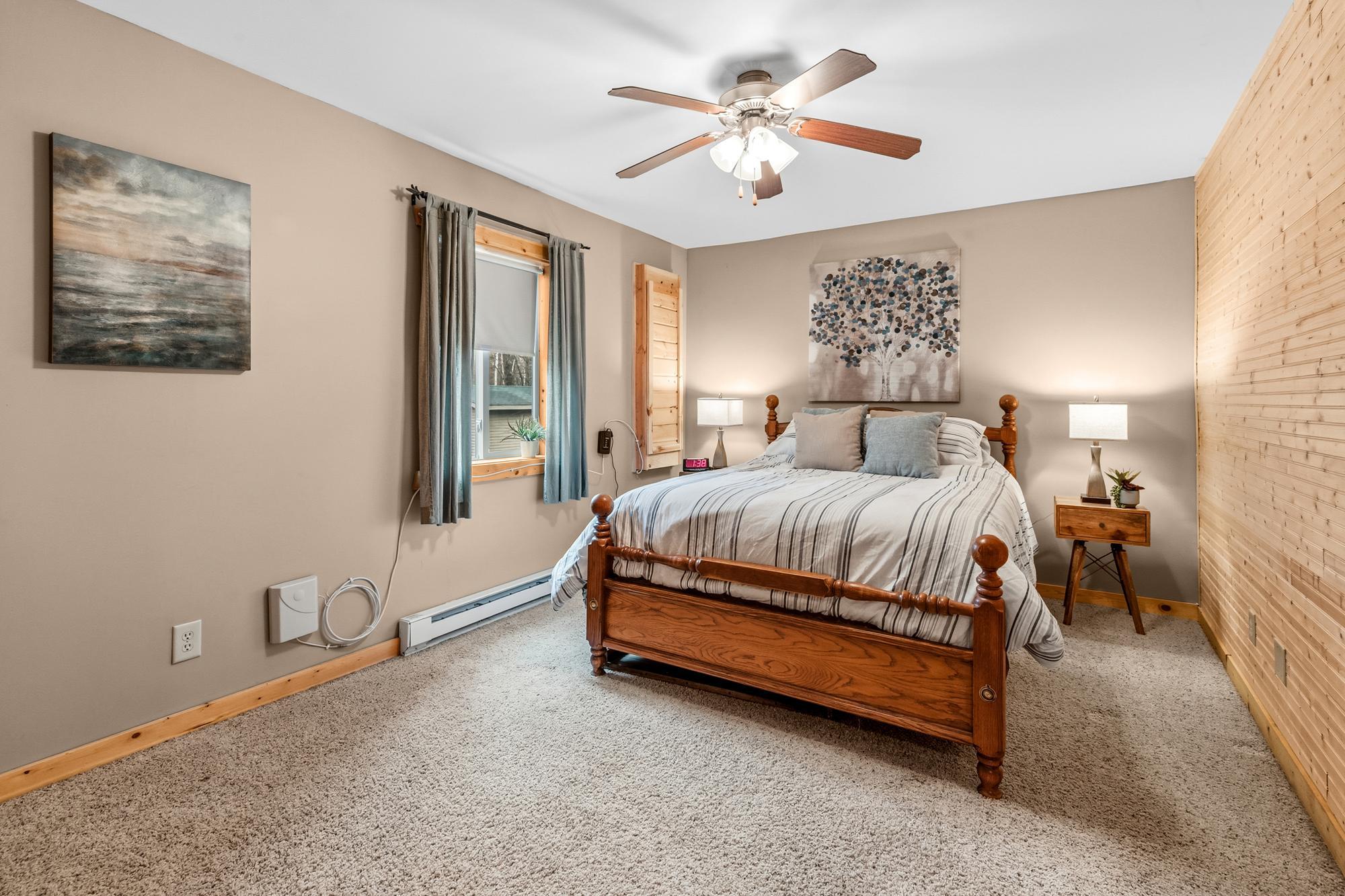 Primary bedroom with electric baseboard, ceiling fan and access to the 100 amp. electrical panel.