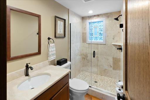 Updated main-level 3/4 bath featuring a tiled walk-in shower and clean, modern finishes.