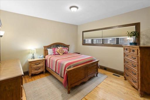 Spacious main-level primary bedroom featuring hardwood floors, neutral tones, and excellent natural light.