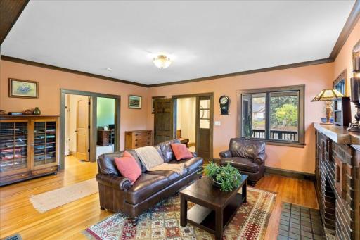 Inviting living room just off the foyer featuring beautiful hardwood floors, original woodwork, and abundant natural light.