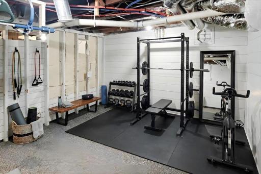 Unfinished lower level space offering excellent storage or future finishing potential. Shown here virtually staged as a workout area.