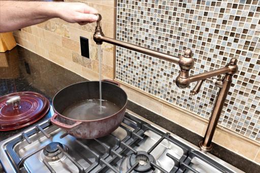 Premium pot filler over the range adds convenience and a high-end touch to this thoughtfully designed kitchen.