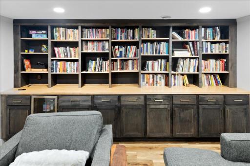 Custom built-in shelving and cabinetry provide excellent storage and display space, also includes mini fridge for cold movie/game drinks!