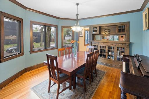 Bright dining space with large windows, original woodwork, and built-in cabinetry, creating a warm and inviting setting for gatherings.