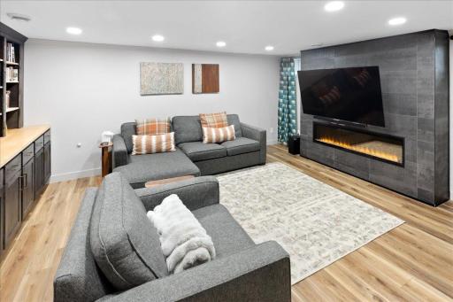 Expansive lower-level family room featuring an electric fireplace, perfect for cozy movie nights and entertaining.