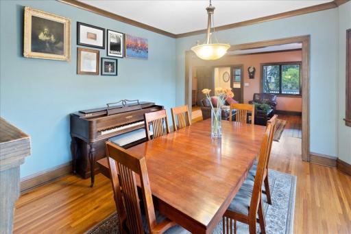Formal dining room with rich hardwood floors and classic millwork, offering a seamless connection to the living area.
