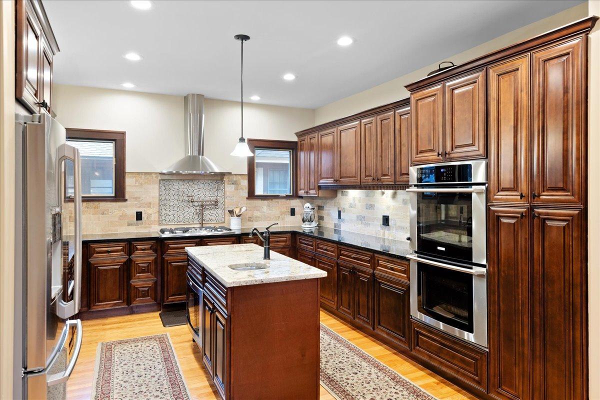 Spacious, custom kitchen with granite countertops, stainless steel appliances, and a center island with prep sink.