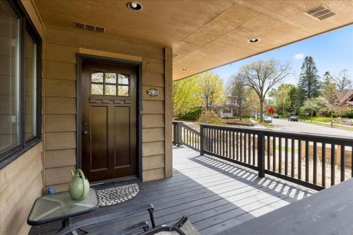 Spacious covered front porch with classic wood detailing. Perfect for relaxing & entertaining, overlooking a quiet, tree-lined street.