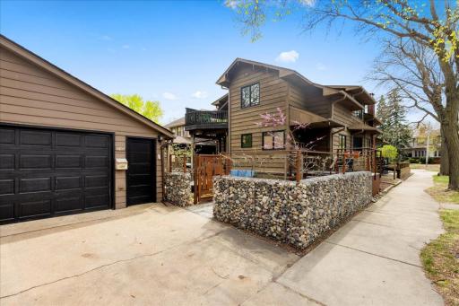 Private backyard retreat featuring a fully enclosed patio with custom stone wall and wood gate. Another area for entertaining, pets, or relaxing outdoors. Includes a 2-car detached garage and additional deck space for extended outdoor living.