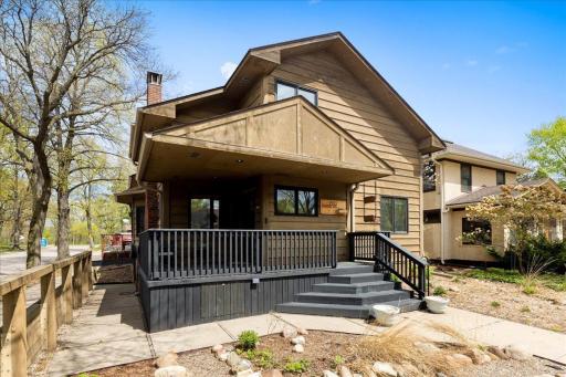 Inviting covered porch, and a beautifully landscaped yard with defined garden beds and wood fencing for added character and curb appeal.