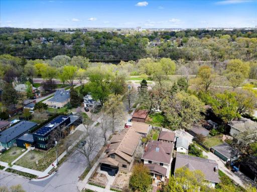 Aerial view highlighting the homeâs prime setting just one block from West River Parkway. Surrounded by mature trees, scenic trails, and close proximity to the Mississippi River and downtown.