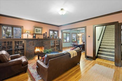 Spacious living area with seamless flow, anchored by a cozy wood-burning fireplace and built-in cabinetry.