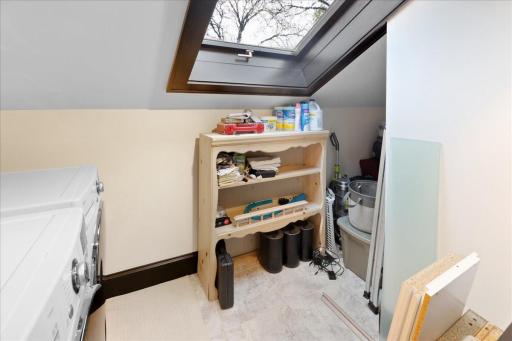 Convenient upper-level laundry area with added storage and natural light.