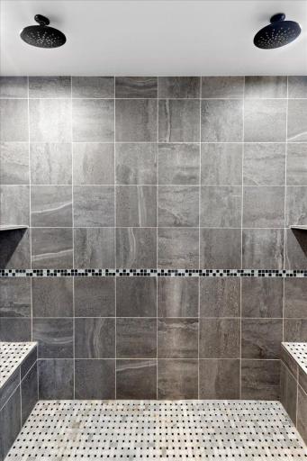 Custom tiled walk-in shower with dual shower heads and modern finishes.