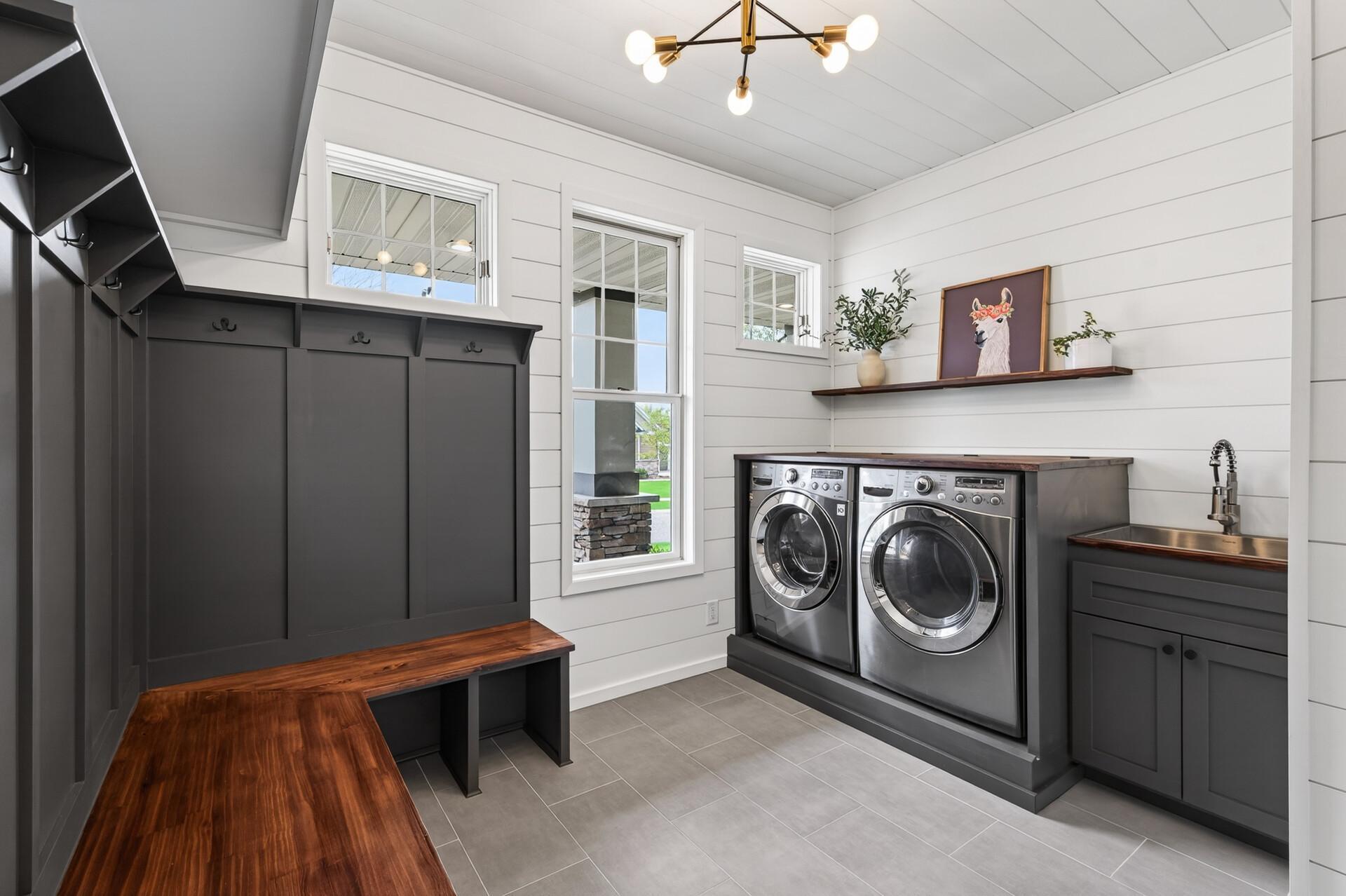 Beautifully remodeled mudroom and laundry space with built-in storage, bench seating, and modern finishes.