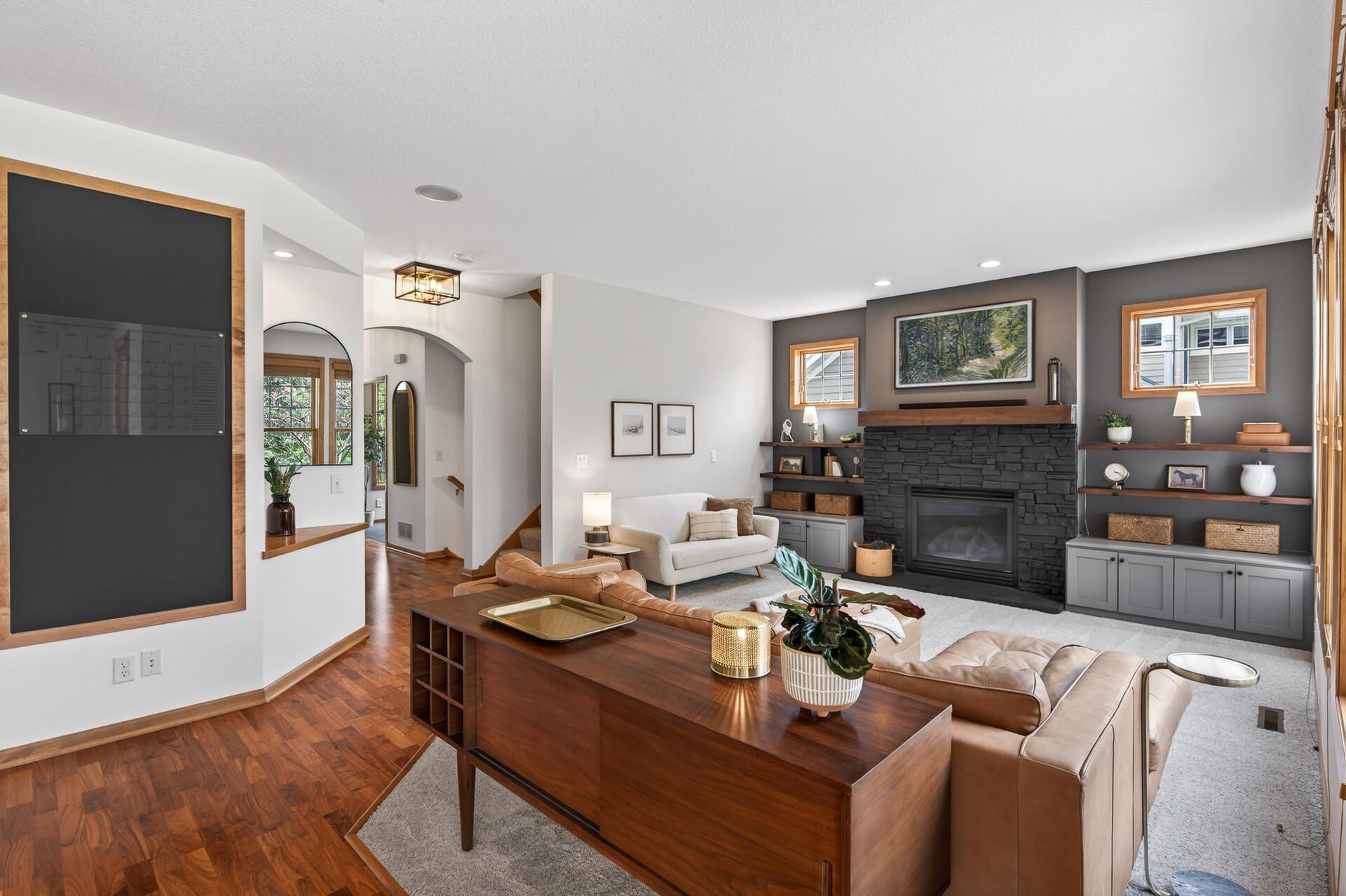Inviting living room with stone fireplace, custom built-ins, and l