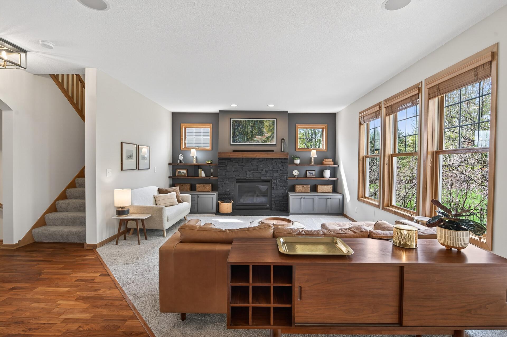 Warm and welcoming living room with fireplace, neutral tones, and seamless flow into surrounding spaces.