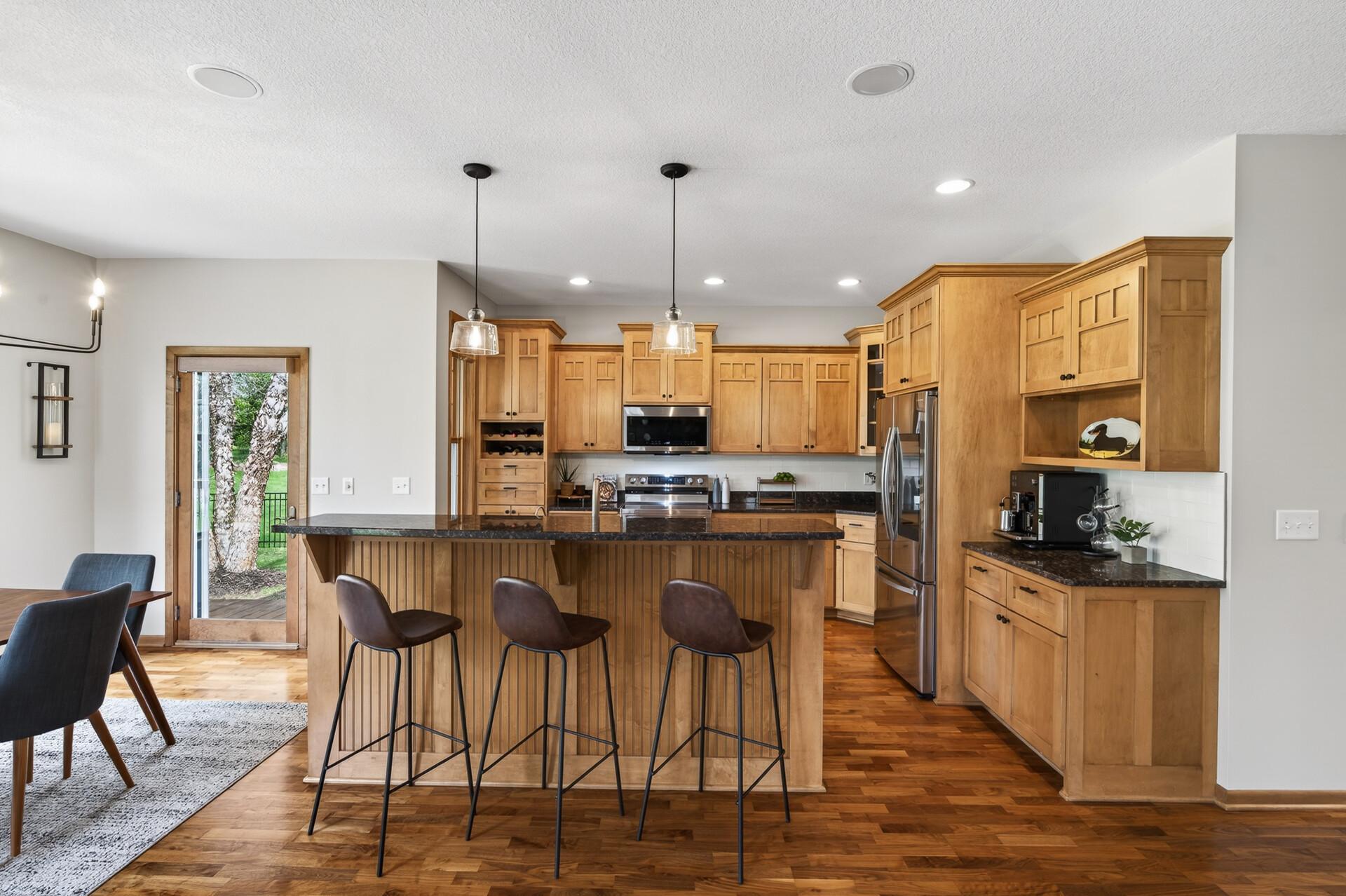 Spacious kitchen with abundant cabinetry, granite countertops, and center island with seating.