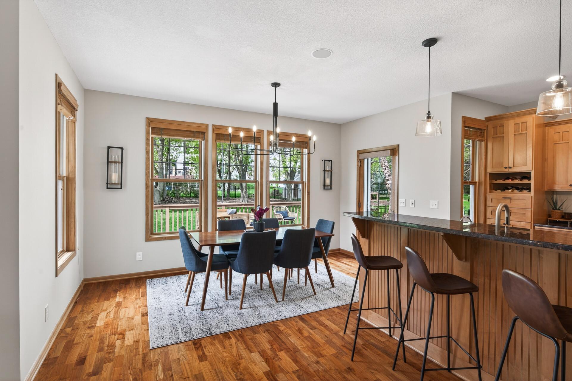 Sun-filled dining space with large windows overlooking the backyard and access to the deck.