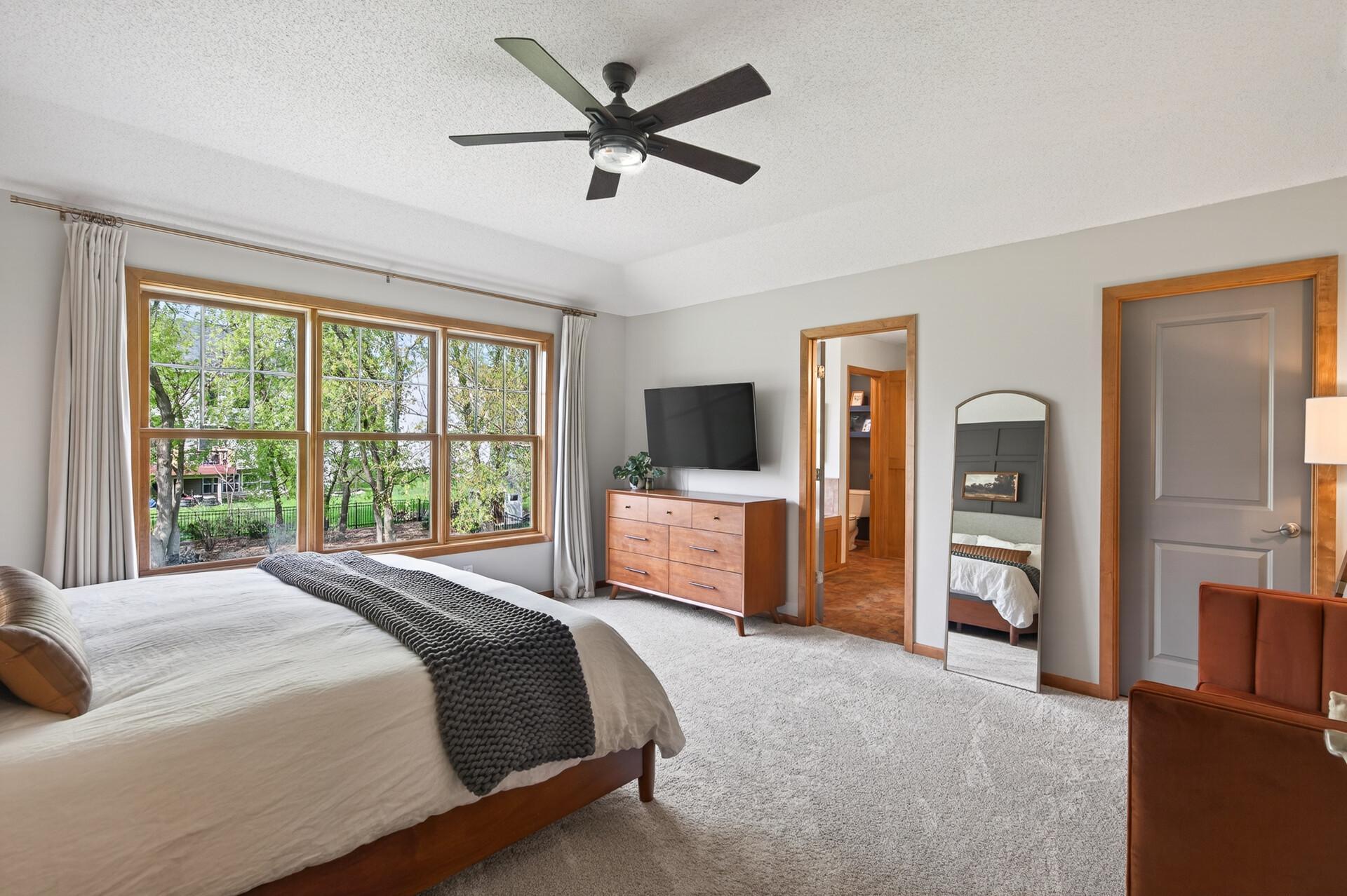 Expansive primary suite with serene backyard views and plenty of room for a full furniture setup.