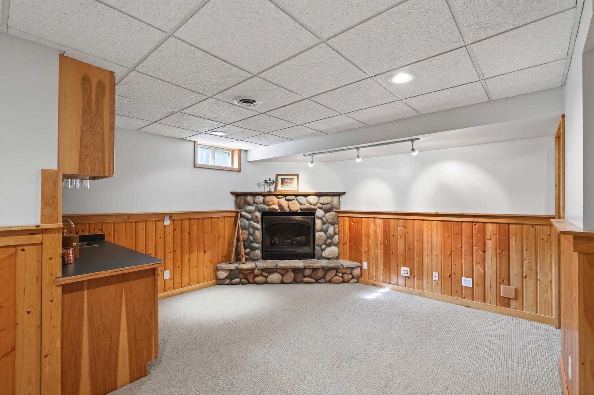 Lower level Family Room features gas stone Fireplace & new carpet
